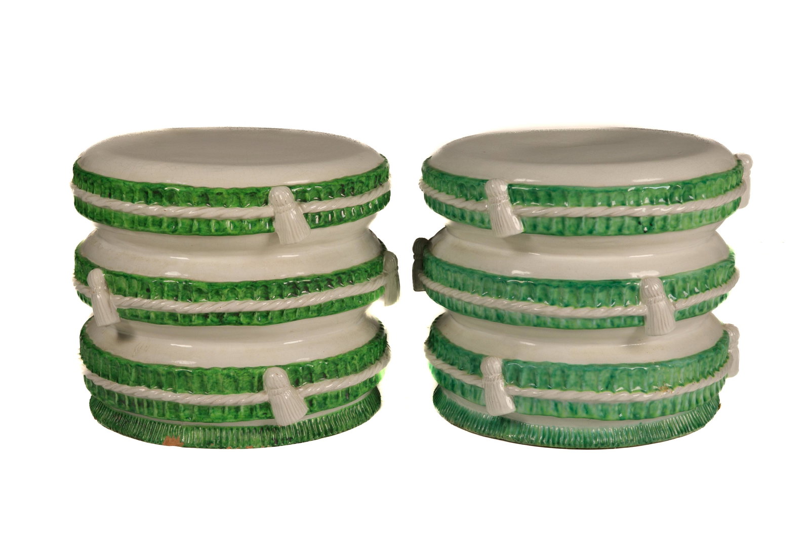 PAIR OF ITALIAN POTTERY STOOLS: Trompe l'oeil in the manner of tasseled cushions in green and white glaze. H. 33 cm (13 in.)There is a chip to the bottom of one.