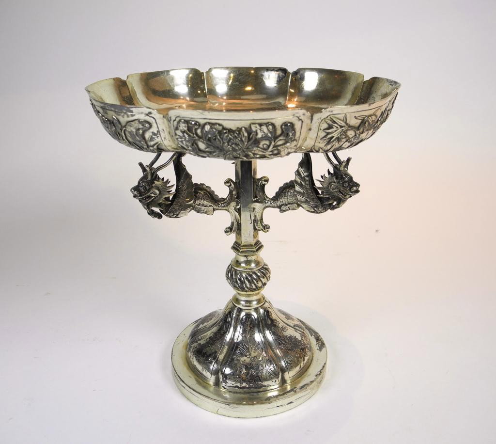 CHINESE EXPORT SILVER COMPORT: Hong Kong Maker Wang Hing, turn of the century. The bowl is supported by three flying dragons branching out from a central column on a stepped lobed foot. The bowl and foot decorated with panels of ba