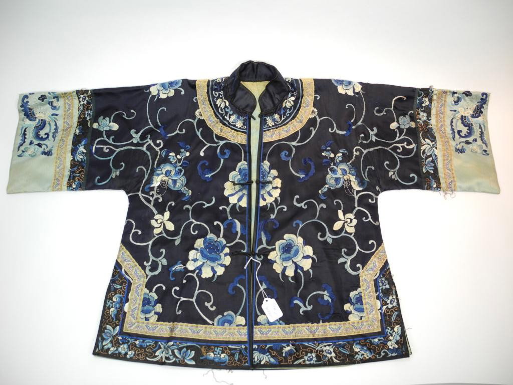 CHINESE EMBROIDED BLUE SILK LADIES ROBE: Decorated with lotus and butterflies on navy grounds, bordered by panels of butterflies and symbols of shou, bats, and plums. The sleeves are similarly adorned with lotus and butterflies on light blue
