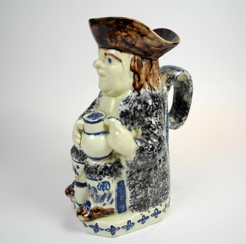 STAFFORDSHIRE TOBY JUG: the seated figure with blue spattered coat and brown hat holding a foaming jug of ale with a barrel between his legs, 19th century, H. 25 cm. (9 3/4 in.) Provenance: From the Estate of Peter and Barba
