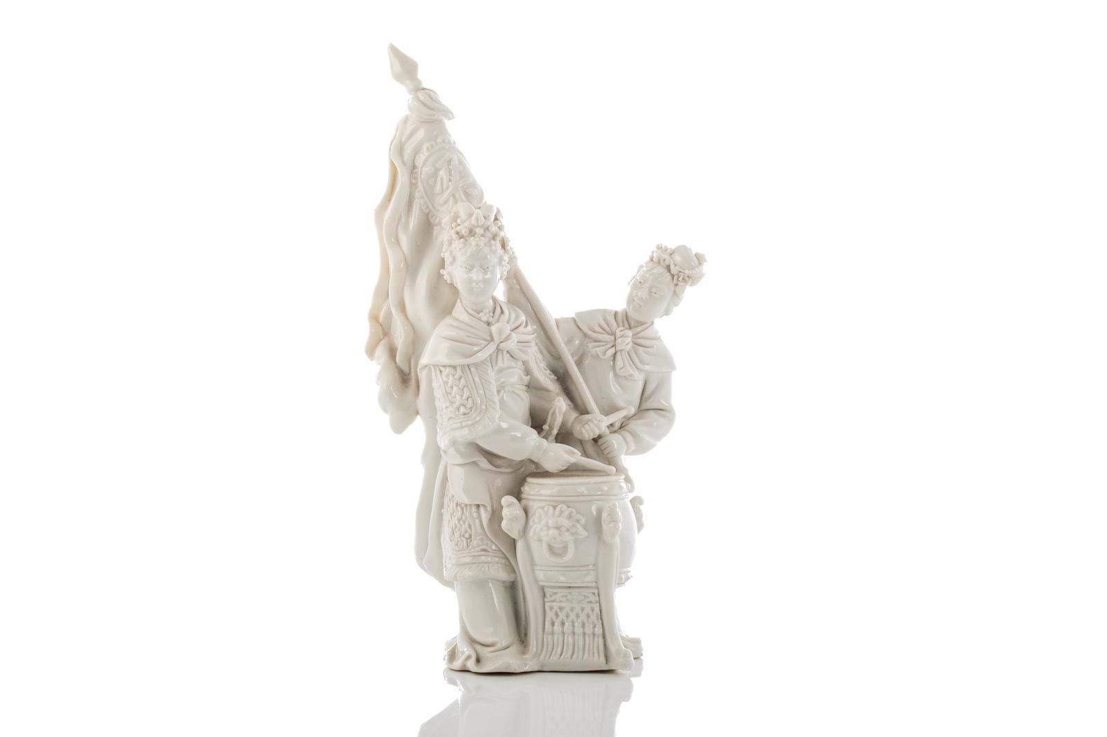 CHINESE DEHUA PORCELAIN FIGURAL GROUP: Chinese, dehua porcelain figural group moulded as Liang Hongyu, the female general of the Southern Song dynasty, beating the drum against the Jin army. Covered in clear glaze and hollowed on theinside