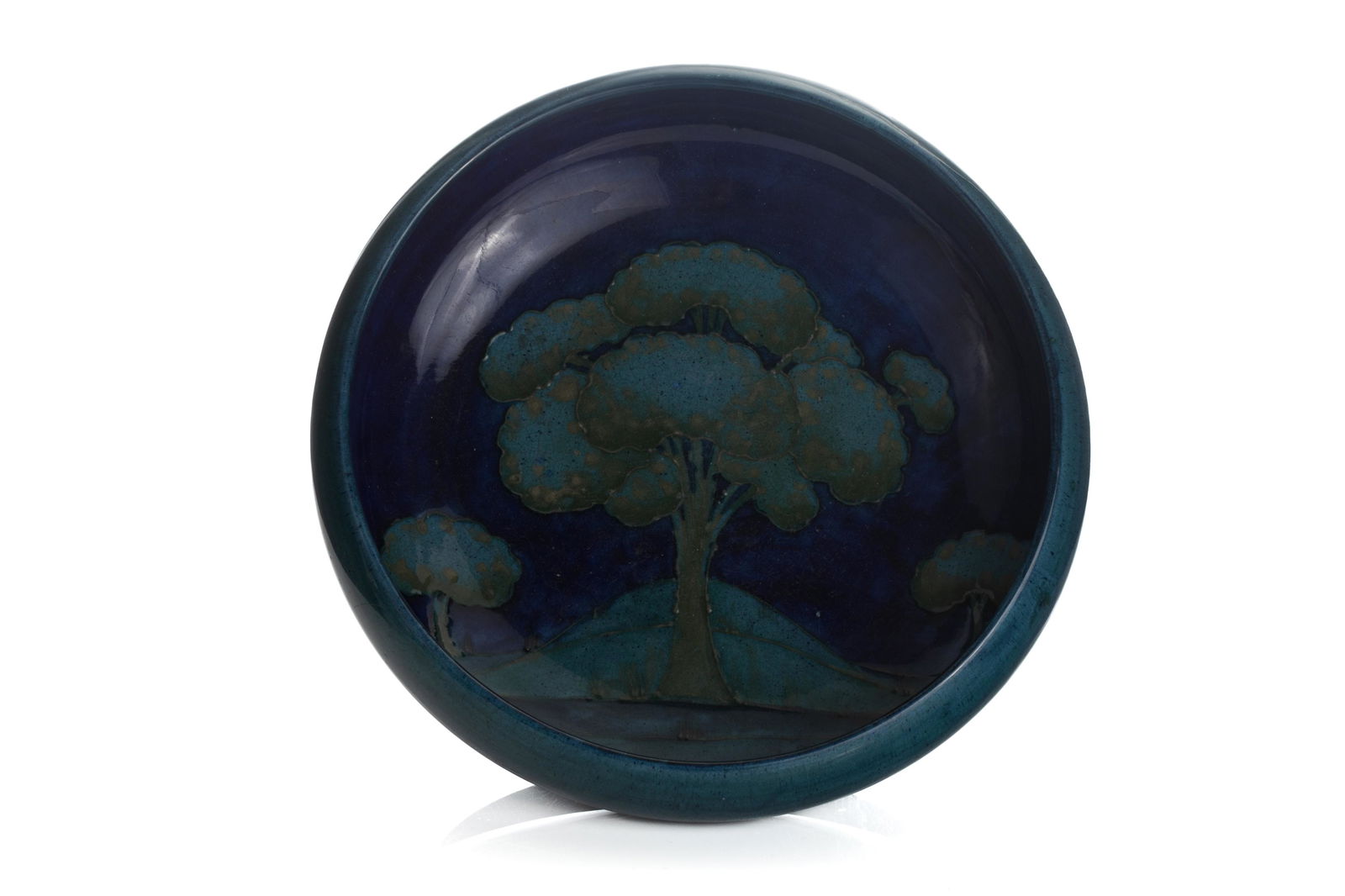 MOORCROFT POTTERY MOONLIT BLUE BOWL: An early 20th C Moorcroft bowl in Moonlit blue to interior signed to base with Moorcroft signature. Dia. 27cm (10 1/2in) Provenance: Old Christie's label to base. Abbey Antiques, Winnipeg Minor scratc