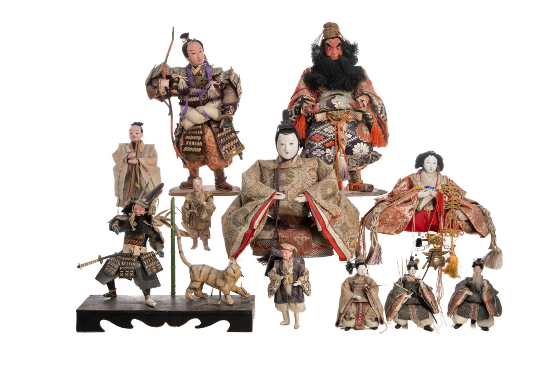 ELEVEN JAPANESE MEIJI PERIOD DOLLS: Japanese, Meiji Period, a group of eleven dolls including Hinamatsuri dolls, the fierce Shoki (Zhong Kui), samurai, along with other seated and standing figures. Each with hand-painted faces, some wit