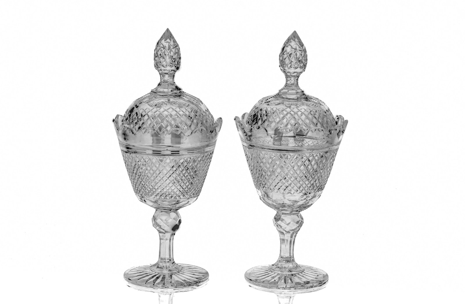 PAIR OF 19TH CENTURY CUT GLASS SWEET MEATS: A pair of antique glass pokals, each with diamond cut design, on circular feet, petal form rims, and tear drop shaped finials. H. 31 cm (12 1/4 in.)