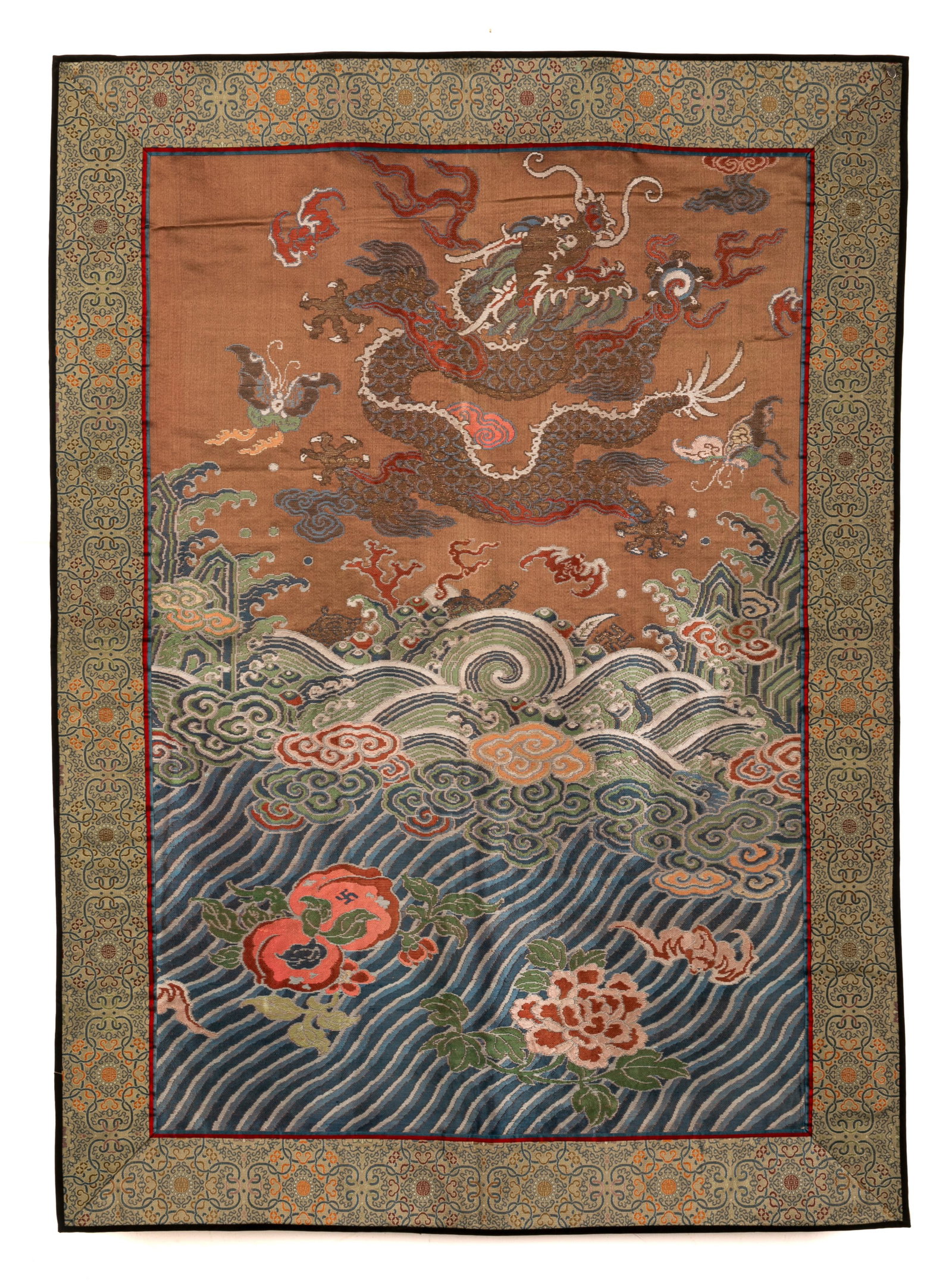 A CHINESE DRAGON & WAVES SILK EMBROIDERED PANEL: Chinese, Qing dynasty, features a dragon above waves against a warm earth tone background. Size of the embroidery: 84.8 x 62.2 cm (33 3/8 x24 1/2 in.)