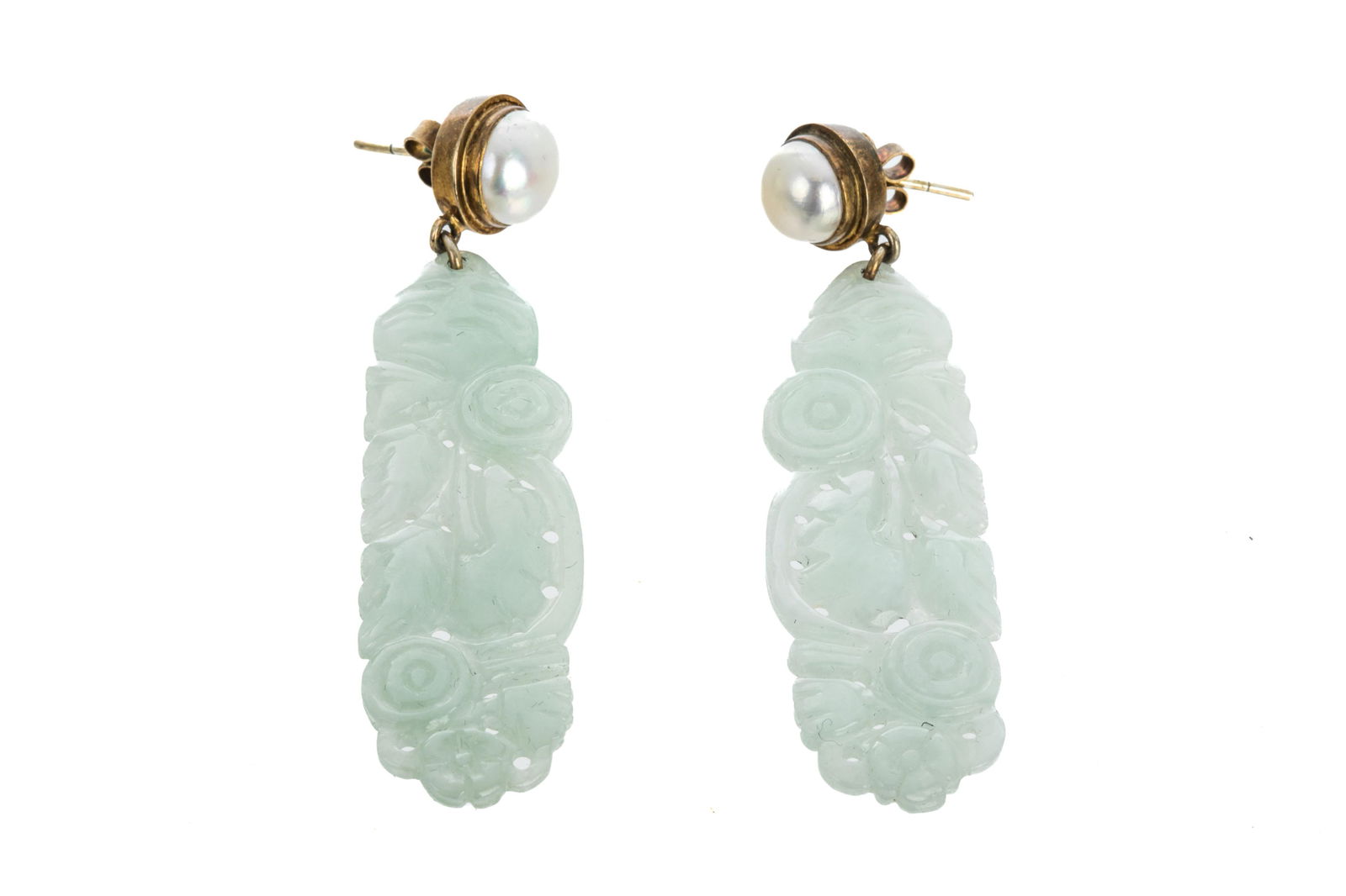 PAIR OF CARVED JADEITE AND CULTURED PEARL EARRINGS: A pair of naturalistic design carved jadeite drop earrings, each with a cultured pearl, set in gilt metal, with stud backings.L. 7cm
