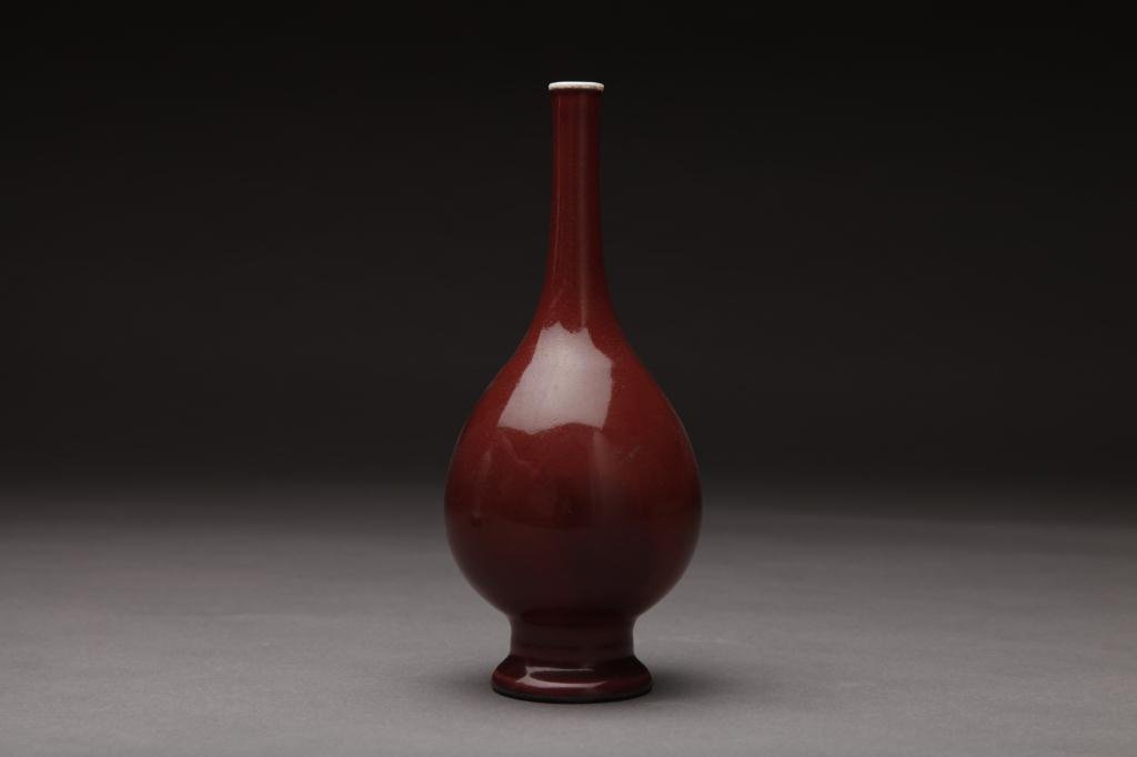 CHINESE OX BLOOD GLAZED BOTTLE VASE: Of slandering neck, with white glaze on rim and base. Republican period Lang kiln. H. 22cm (8.6 in.)
