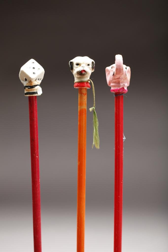 LOT OF THREE CHILDREN'S CANE: Two canes with painted elephant and dog knobs and one with porcelain dice knob. All are of L. 85cm (33.46 in.)