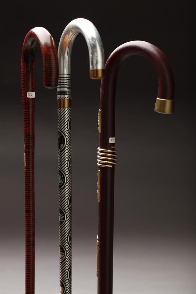 THREE WORLD'S FAIR SOUVENIRE WALKING STICKS: Of a painted silver-black 1934 Chicago World's Fair cane; a red zebra pattern 1939 New York World's Fair cane; and a 1963 Montreal World's Expo cane. L. 93cm (36.6 in.)/ 89cm (35 in.)