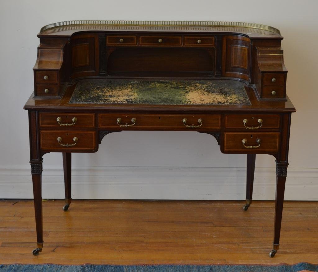 EDWARDIAN CARLTON HOUSE DESK: Mahogany with satinwood inlay and brass gallery to top with tooled leather writing surface. Pigeon hole and drawer interior. Tapered legs with brass castors. With geo. style chair and drop in seat. 46