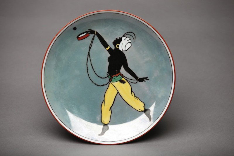 NORITAKE LUSTRE SILHOUETTE PLATE: Blue lustre ground with a nude belly dancer. Red M-in-Wreath, Dia 21.5 cm. (8 1/2 in.)