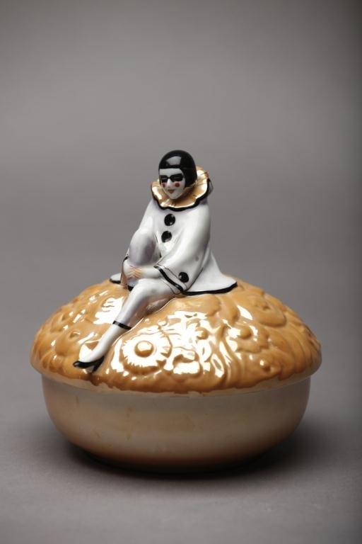 NORITAKE LARGE FIGURAL DRESSER JAR: Moulded caramel lustre body with a seated Pierrette (loss to lustre outfit). Red M-in-Wreath, Dia 16.7 cm. (6 5/8 in.)
