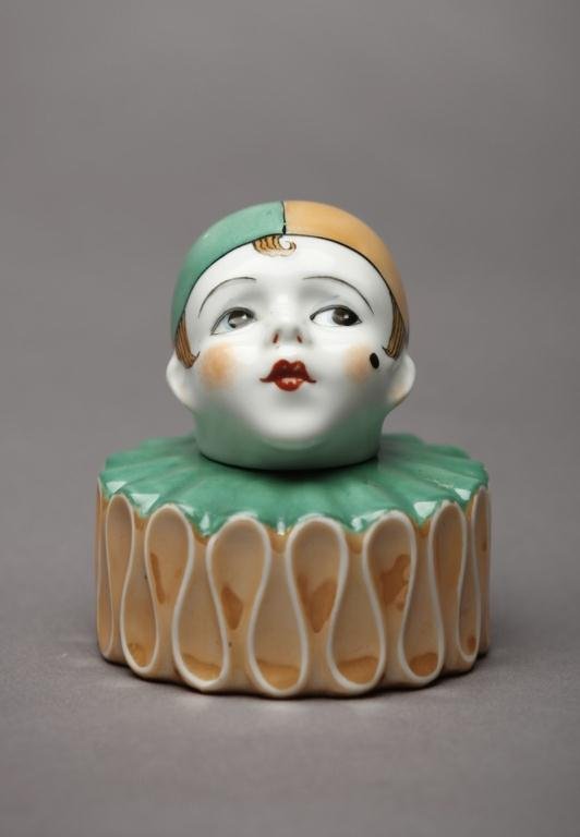 NORITAKE FIGURAL INKSTAND: Of a clown's head and ruffled collar in caramel and matte green. English Spoke mark, 15.01. H 10.5 cm. (4 1/8 in.)