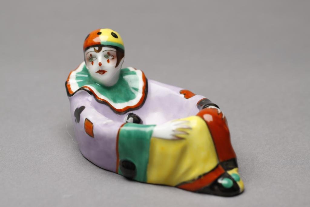 NORITAKE FIGURAL RING DISH: Polychrome harlequin with playing-card-suit coat. English Spoke, 15.01. L 12.8 cm. (5 in.)