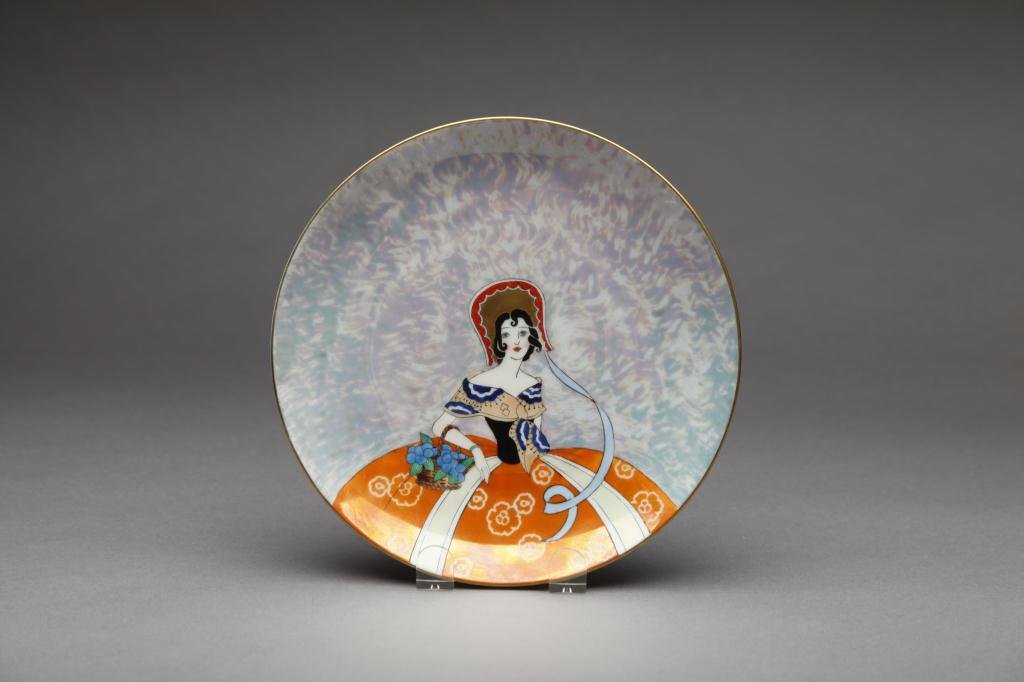 NORITAKE LUSTRE PLATE: Mottled purple lustre ground with Southern Belle in an orange skirt. Red M-in-Wreath, Dia 22 cm. (8 5/8 in.)