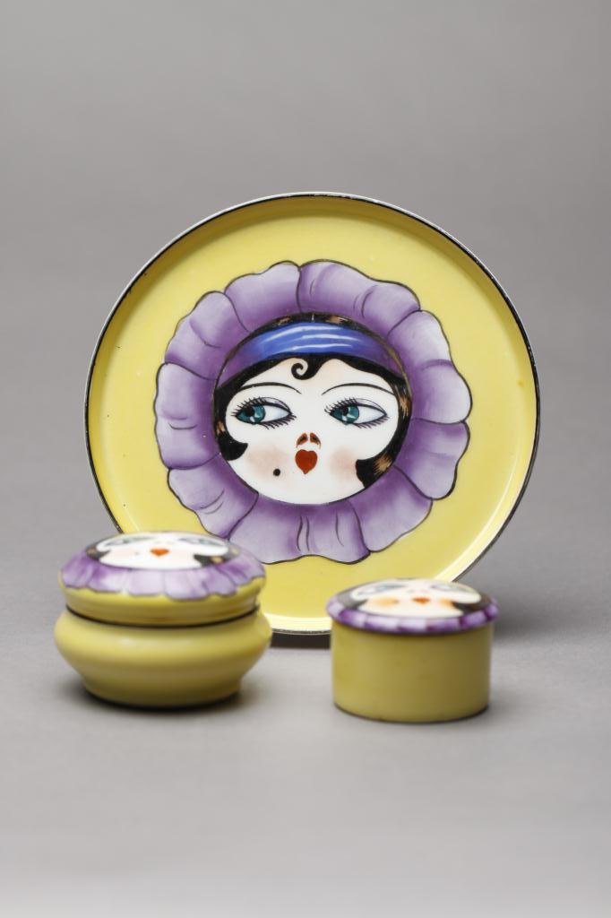 THREE PIECE NORITAKE DRESSER SET: Each of matte yellow ground with Betty Boop-style in a purple flower. Consisting of two jars and a tray. Unmarked. Dia of tray 13.5 cm. (5 3/8 in.)