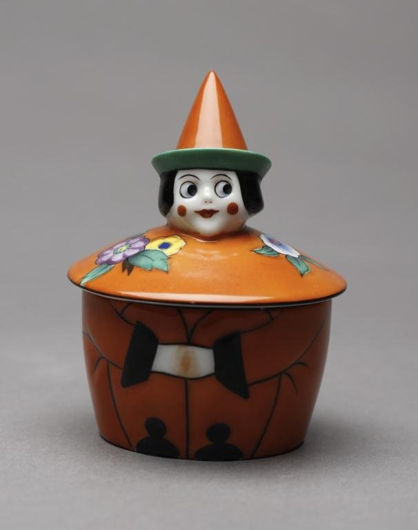 NORITAKE FIGURAL CLOWN INKWELL: Moulded orange glaze body with rosy cheeks and a cone hat. Red M-in-Wreath, H 10.2 cm. (4 in.)