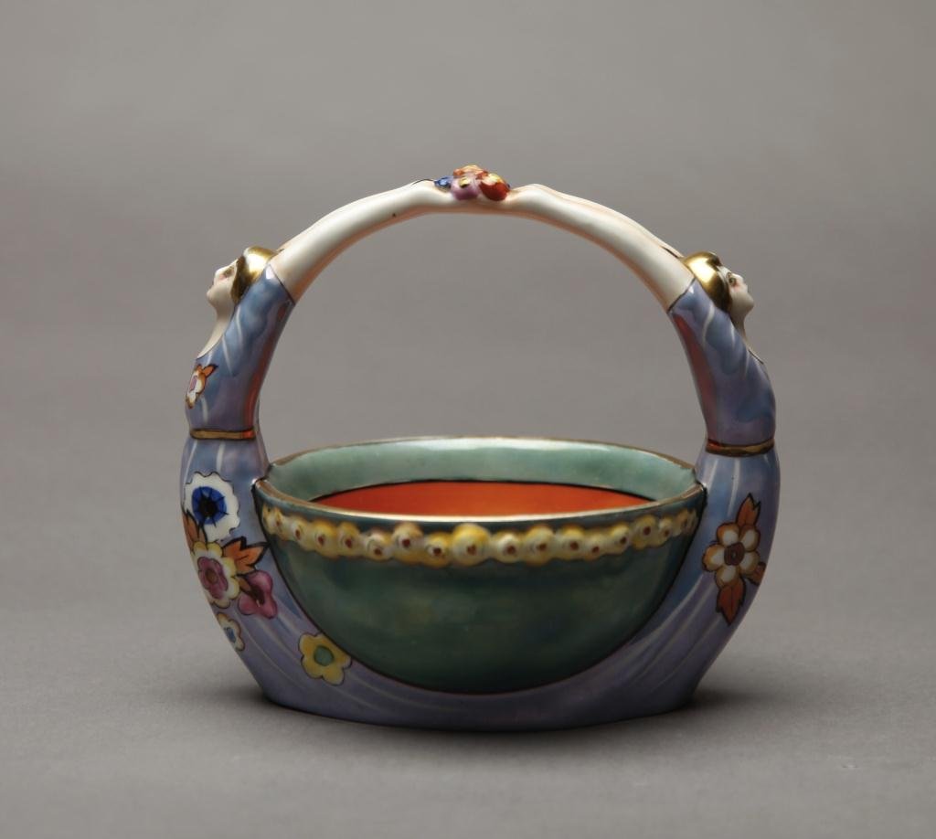NORITAKE GEMINI FIGURAL BASKET: Green lustre bowl with flappers flanking each side with outstretched arts becoming the handle. Red M-in-Wreath, L 16 cm. (6 1/4 in.)