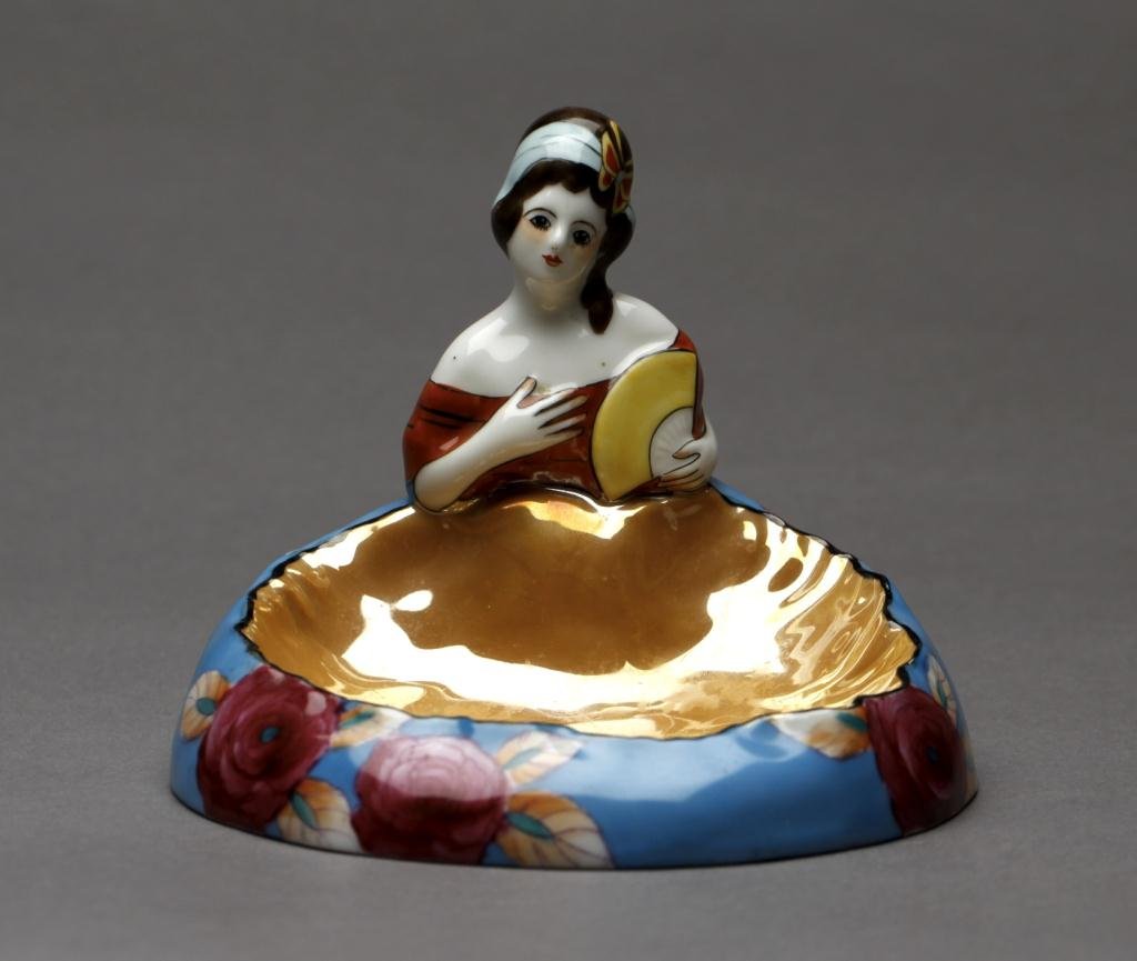 NORITAKE FIGURAL TRINKET DISH: Caramel lustre shell dish with blue exterior and a half doll lady with fan. Green M-in-Wreath, Dia 13 cm. (5 1/8 in.)