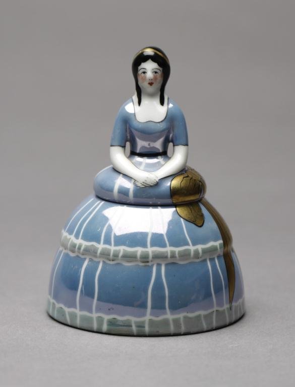 NORITAKE LUSTRE FIGURAL INKWELL: Of a lady in a blue dress with gold bow. English Spoke mark, H 11.5 cm. (4 1/2 in.)