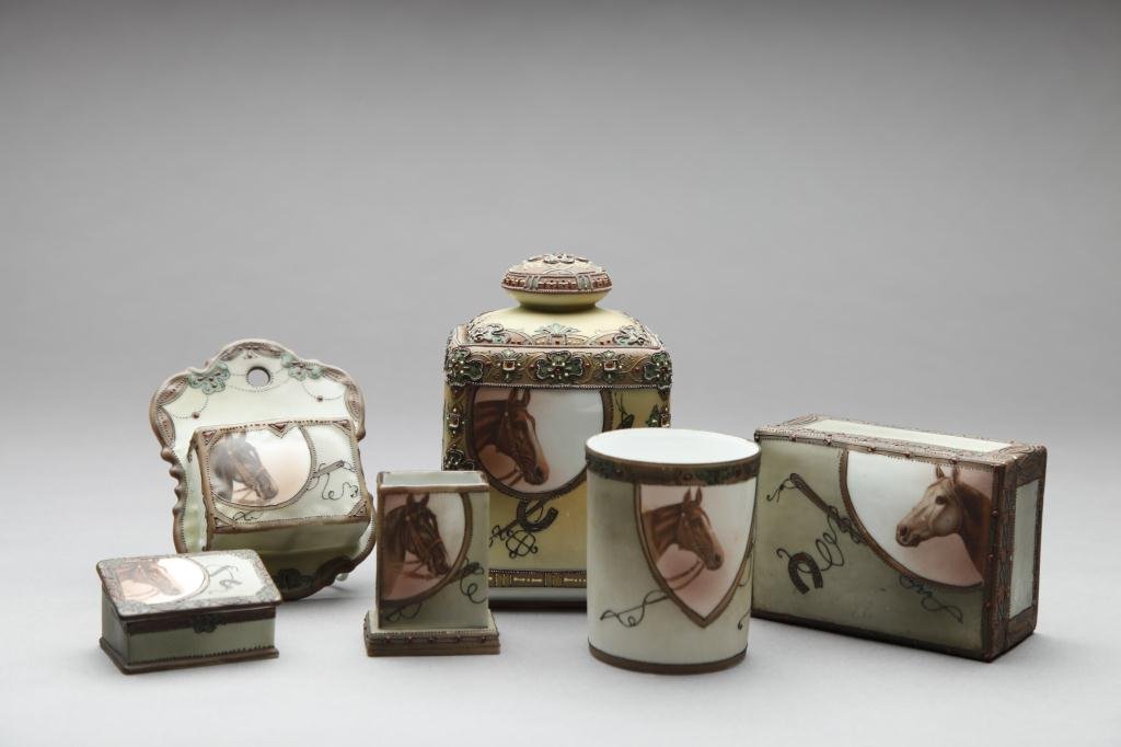 NIPPON SIX PIECE HAND PAINTED SMOKE SET: Each with a horse head and horseshoe. Comprising: a box, cigarette holder, match holder, wall pocket, double wall box and humidor. Green M-in-Wreath, H of humidor 15.5 cm. (6 1/8 in.) Repaired chip to