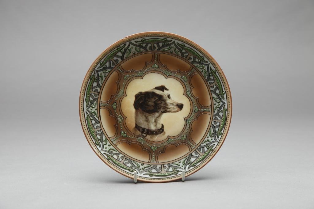 NIPPON HAND PAINTED DOG PLAQUE: Terrier surrounded by an elaborate moriage border in green and blue. Blue Maple Leaf, Dia 22.2 cm. (8 3/4 in.) Four moriage beads missing