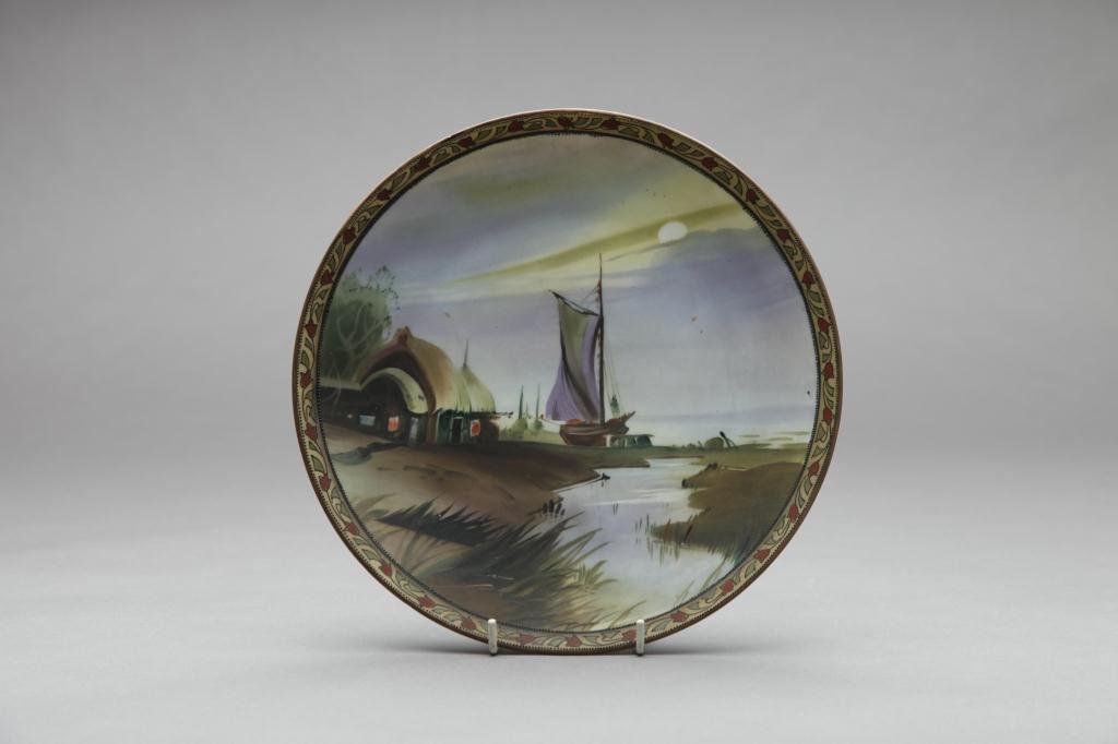 NIPPON HAND PAINTED PLAQUE: Of a harbour scene at sunset with moriage border. Green M-in-Wreath, Dia 25.7 cm. (10 1/8 in.)