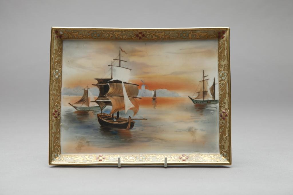 NIPPON HAND PAINTED RECTANGULAR PLAQUE: Of ships in the harbour with foliage gilt and enamel border. Green M-in-Wreath, L 26.7 cm. (10 1/2 in.) One petal of enamel flower is missing