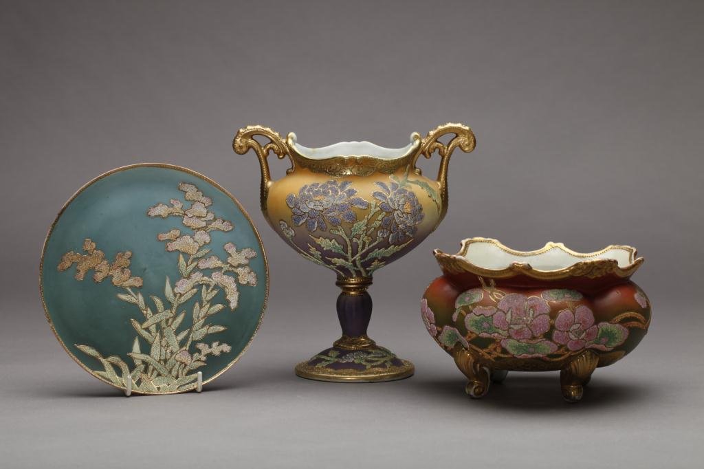 THREE PIECES OF NIPPON CORALENE: A two handled urn with purple ground, open jardiniere on a red to green ground and blue satin plate (all with condition). Patent mark, H of urn 21.9 cm. (8 5/8 in.) Urn: restoration to stem and handle