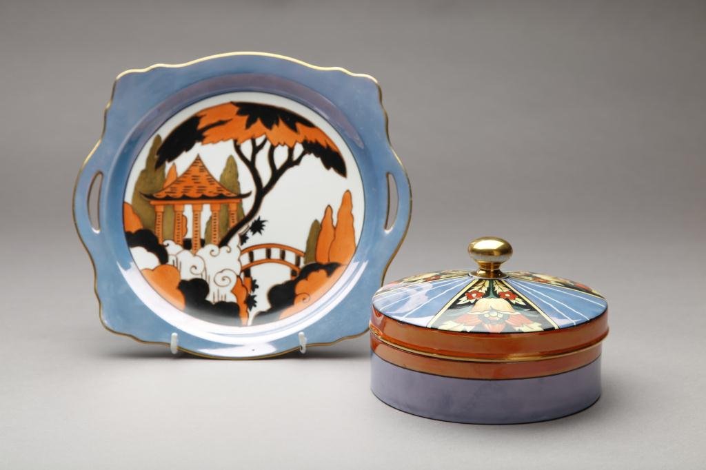TWO PIECES OF GEOMETRIC ART DECO NORITAKE: Box and tray in orange and blue lustre. Green M-In-Wreath & Red Blossom, L of tray 25.7 cm. (10 1/8 in.) Very minor flake to interior rim of box