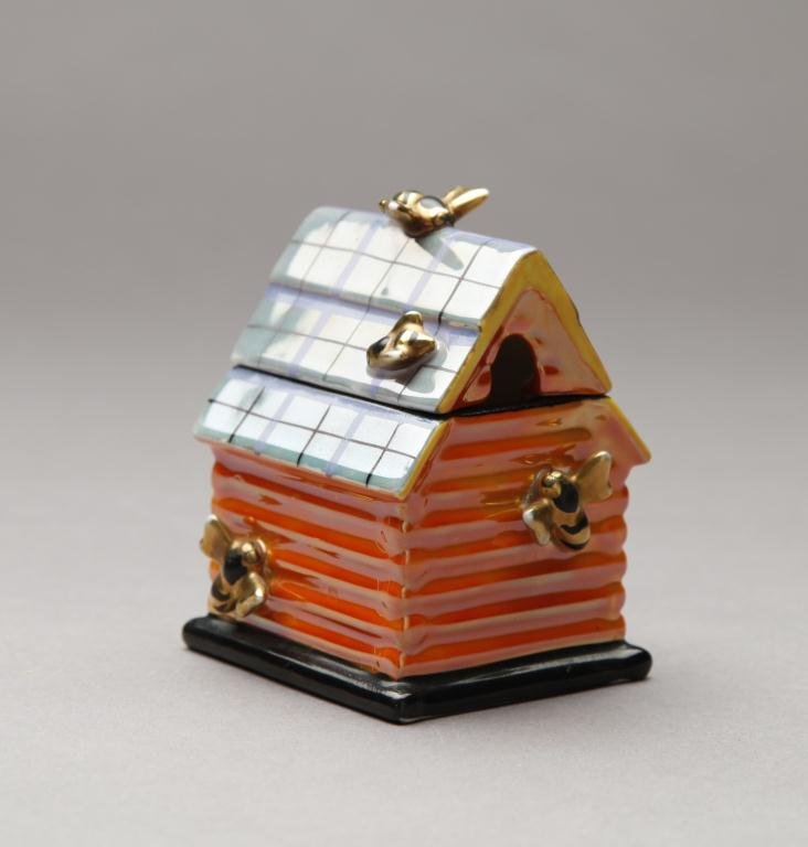 NORITAKE FIGURAL HONEY POT: Moulded as a house in plaid and orange lustre with two bees. Red M-In-Wreath, H 9.5 cm. (3 3/4 in.)