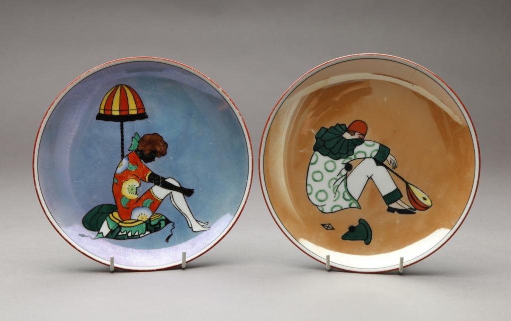 TWO NORITAKE FIGURAL LUSTRE PLATES: Pierot with mandolin or caramel lustre (hairline) and Beachgirl with umbrella on blue lustre (worn). Red M-In-Wreath, Dia 21.7 cm. (8 3/4 in.)