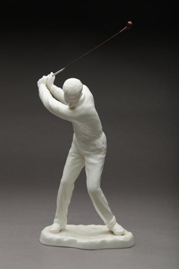 NORITAKE BLANC-DE-CHINE FIGURE OF A GOLFER: In mid swing with a metal club. H 30.5 cm (12in)