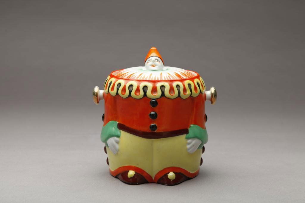 JAPANESE PORCELAIN CLOWN COOKIE JAR: In orange and yellow costume. H 17.5 cm (6 7/8 in)