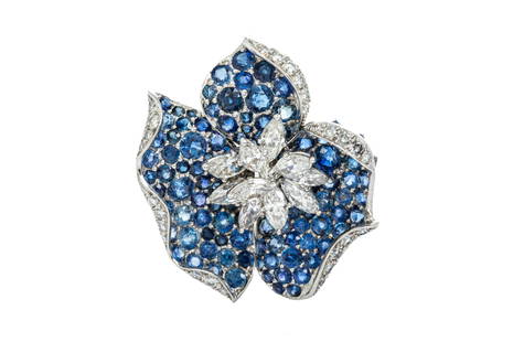 18K GOLD SAPPHIRE AND DIAMOND BROOCH PENDANT, 16g: An 18k white gold three-petal sapphire flower shaped brooch, with a central diamond cluster and diamond edging on the petals, in the manner of Van Cleef. Comprising of approximately one