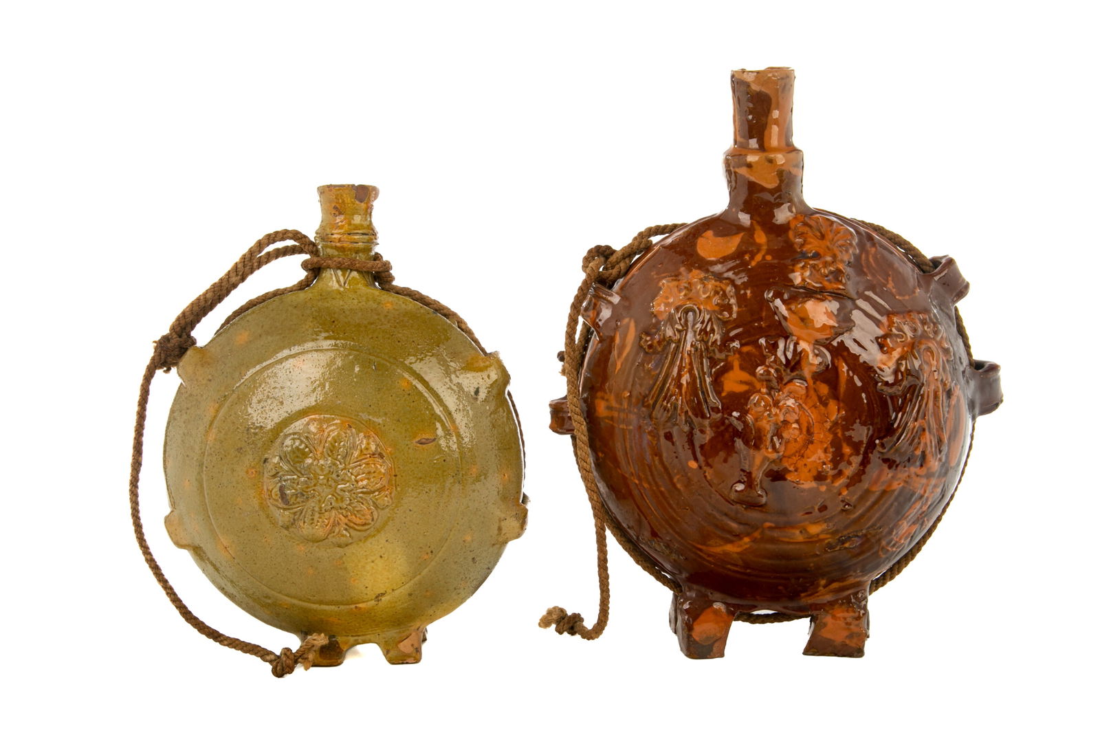 TWO PRE-COLUMBIAN GLAZED POTTERY FLASKS: Two glazed terracotta pottery decorated flasks or canteens in green and red. Both with circular body, feet, open spouts, and later rope. H. of taller: 28.5 cm (11 1/4 in.)