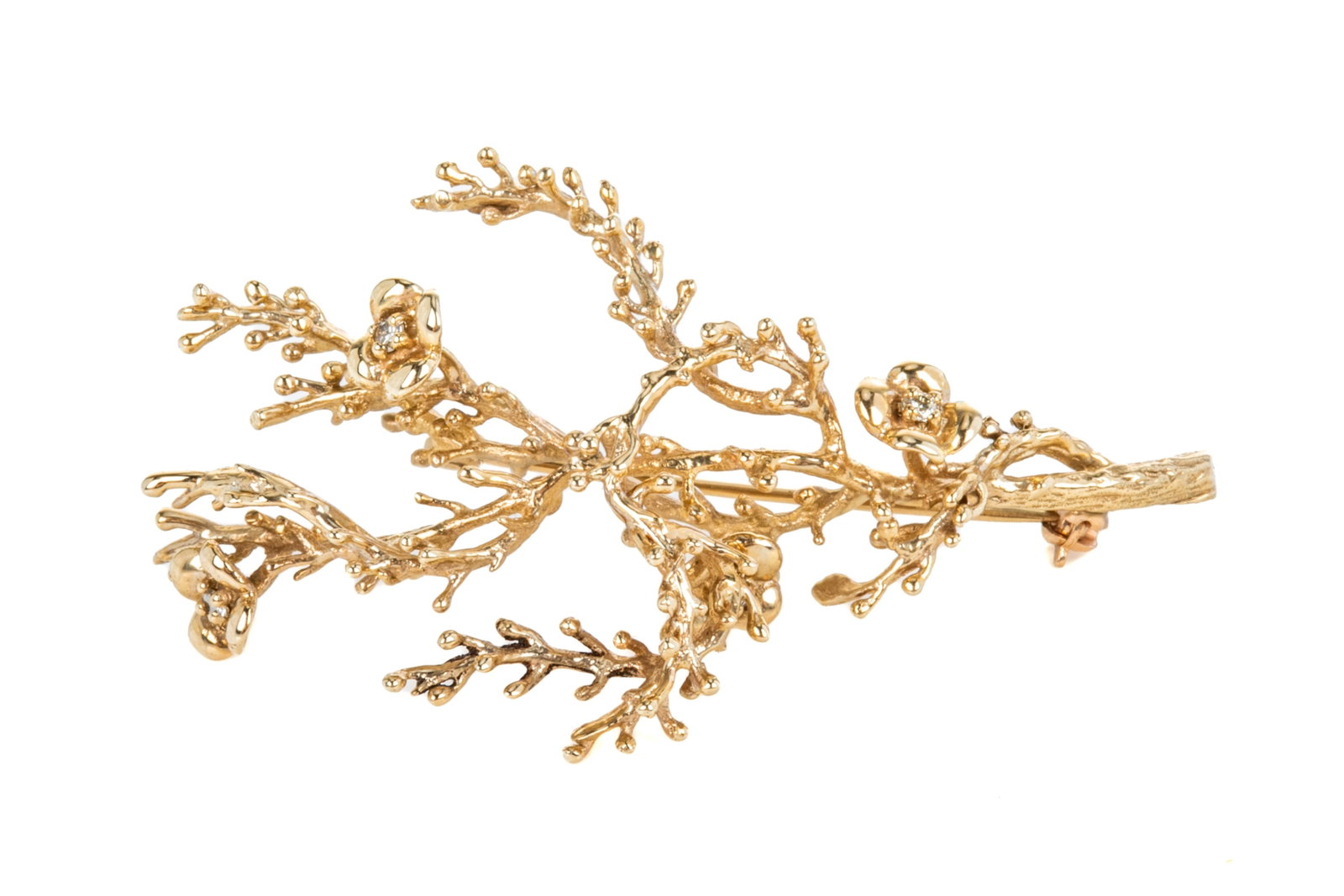 10K YELLOW GOLD AND DIAMOND BRANCH BROOCH, 9g: A 10k yellow gold brooch, in the shape of a branch with four flowers, each set with a small diamond, pin closure, testing 10k.L.: 5.5 cm (2 1/8 in.)
