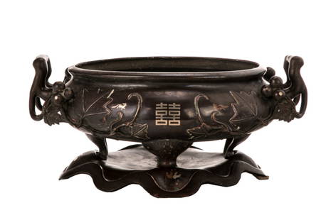 A CHINESE BRONZE & MIXED INLAY INCENSE BURNER: Chinese, late Qing dynasty, copper alloy bronze inlaid incense burner, with a lotus leaf-shape stand. On the burner, the relief motifs of the grape and leaves are well-rounded