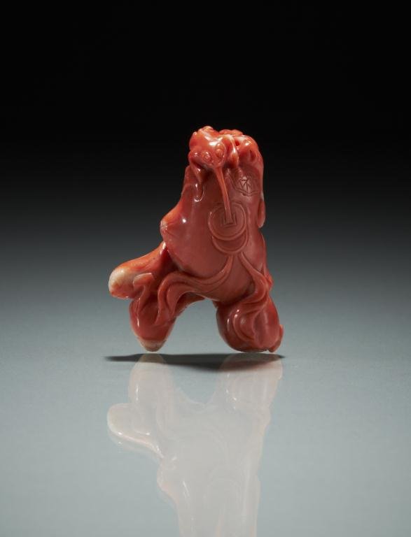 CHINESE FINELY CARVED CORAL BEAD PENDANT: Carved as a peach tree with two frogs. H 4 cm. (1 3/4 in.) Provenance: from the collection of Mr. Abraham Abraham of The Jade Shop, Toronto.