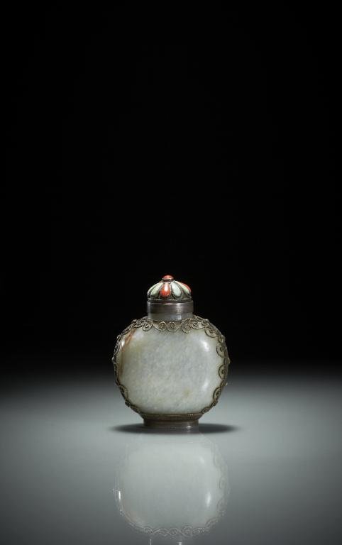 MONGOLIAN WHITE JADE AND SILVER SNUFF BOTTLE: White jade with cloudy inclusions and russet veins, with silver filigree frame and stopper set with coral and turquoise stones. H. 7cm ( 23/4 in.) Provenance: from the collection of Mr. Abraham Abraha