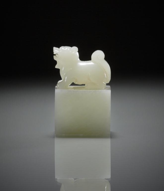 CHINESE CARVED JADE FU DOG SEAL: Square pale celadon jade carved with a sitting fu dog as a finial. H. 4.5cm (1 3/4 in.) Provenance: from the collection of Mr. Abraham Abraham of The Jade Shop, Toronto.