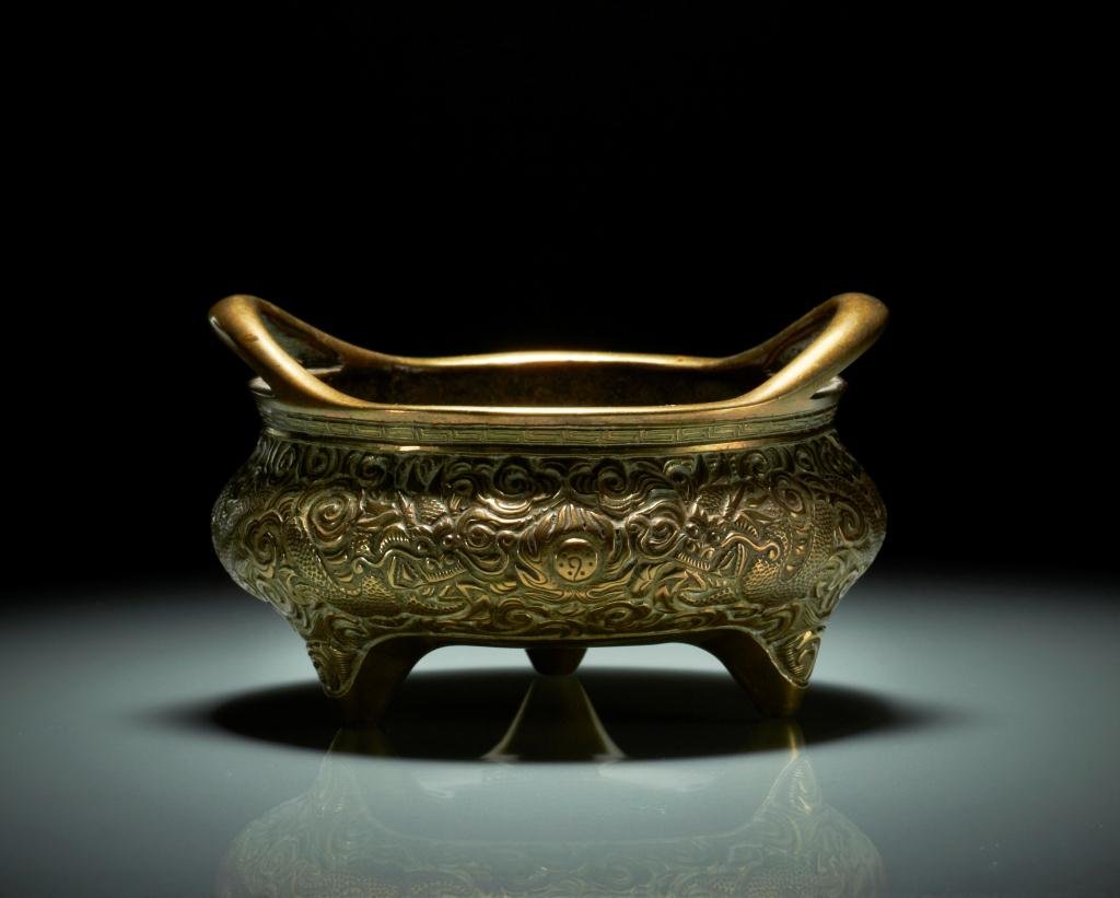 19TH CENTURY CHINESE BRONZE CENSER: With cast dragons and fire motif on tripod feet, apocryphal Ming six-character Xuan De mark. Weight of censer: 961g. L 13.7cm. (5 1/2 in.) Provenance: from the collection of Mr. Abraham Abraham of The