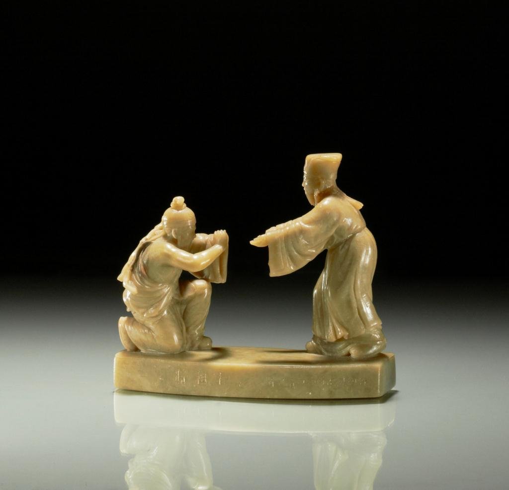 CARVED QINGTIAN SOAPSTONE FIGURAL GROUP: Depicting a scene from Shiji, base is engraved with the story title and "Zhejiang Qingtian Youzhu Shikezu zhi." L. 12.5cm (4 7/8 in.)