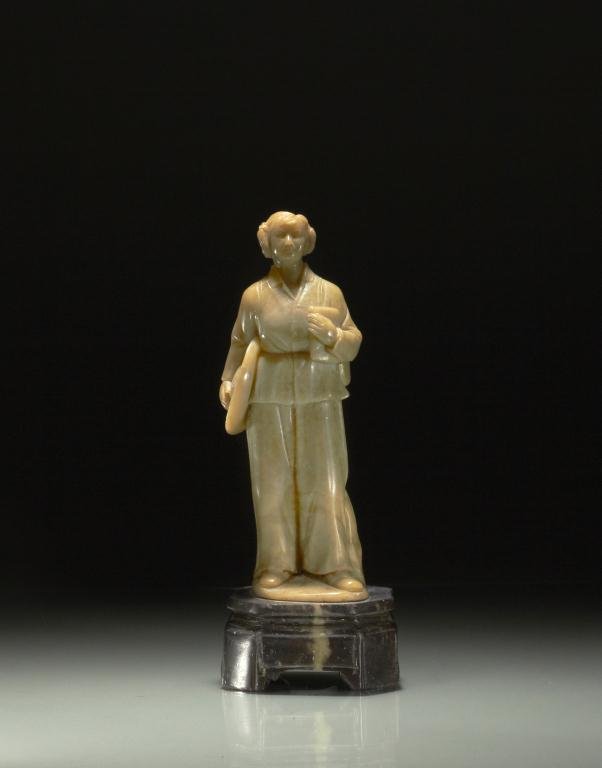 CARVED QINGTIAN SOAPSTONE FIGURE: Carved as a young Cultural Revolution female barefoot doctor on a stand. H. 20cm (7 7/8 in.)