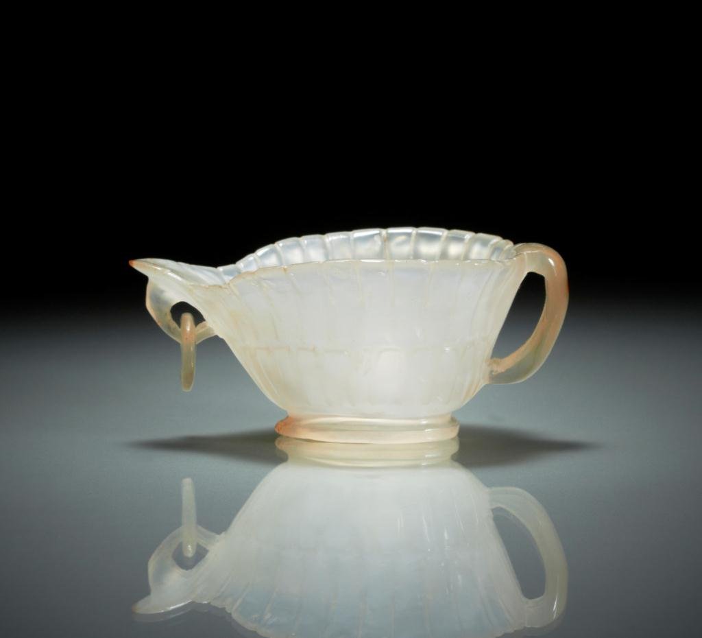 CARVED AGATE MUGHAL CUP: Translucent white agate with fluted body, with loop handle and mobile ring to mouth. L. 7.7cm ( 3 in.)