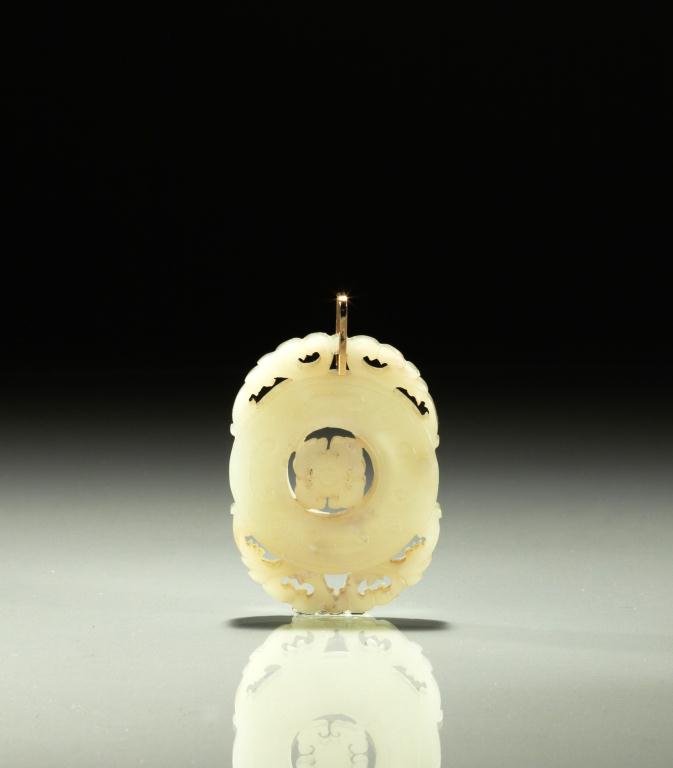 CARVED JADE PUZZLE PENDANT DISC: Celadon jade with pierced border and rotating disc centre. H 6.1 cm. (2 1/2 in.)