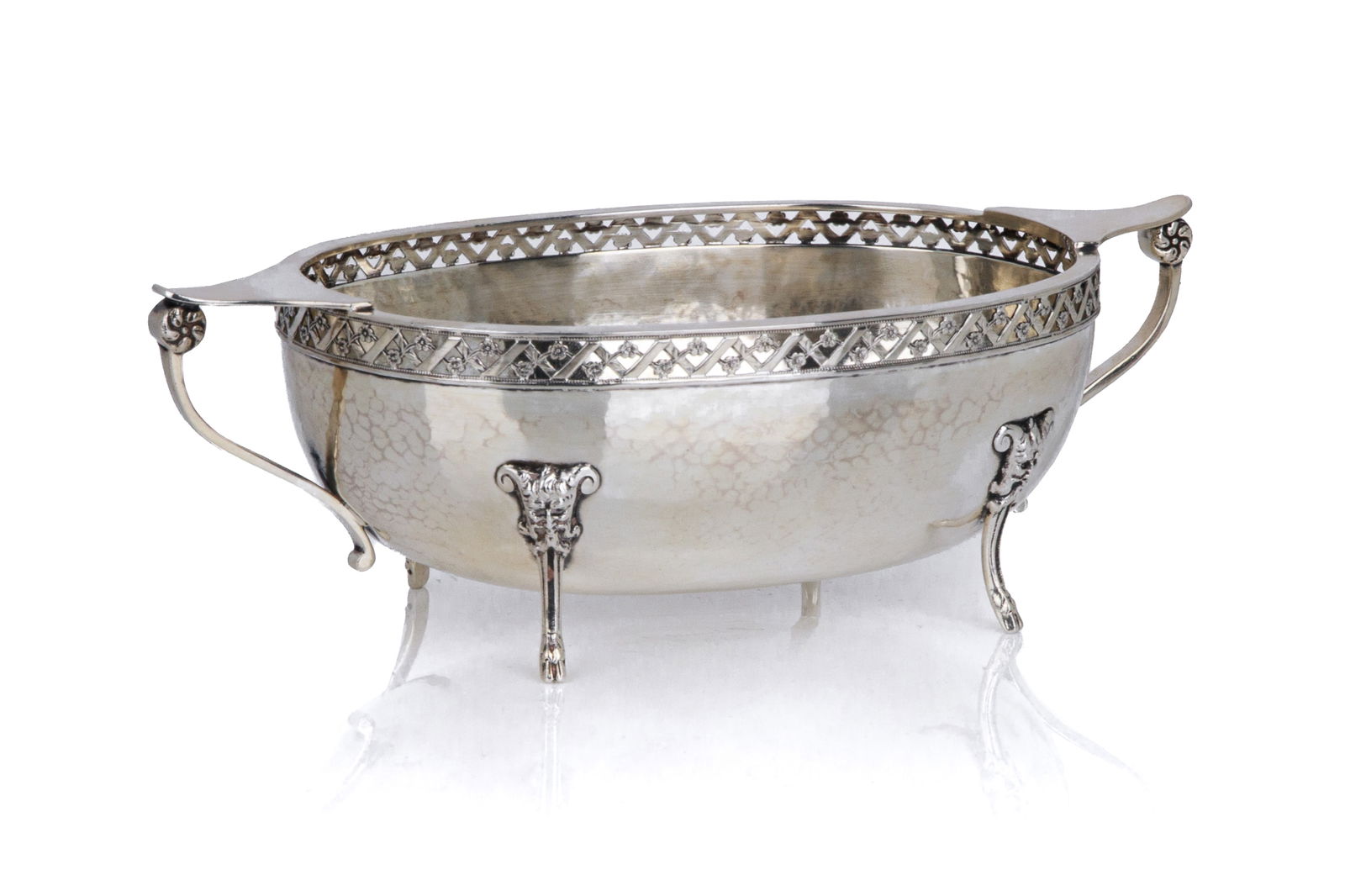 A. E. JONES SILVER TWO-HANDLED SUGAR BOWL, 244g: A two handled hand hammered dish with a pierced border in the style of a garden lattice. A.E. Jones, Birmingham 1934. Unusually also has facsimile signature on base. L.: 21 cm (8 1/4 in.) 244g of weig