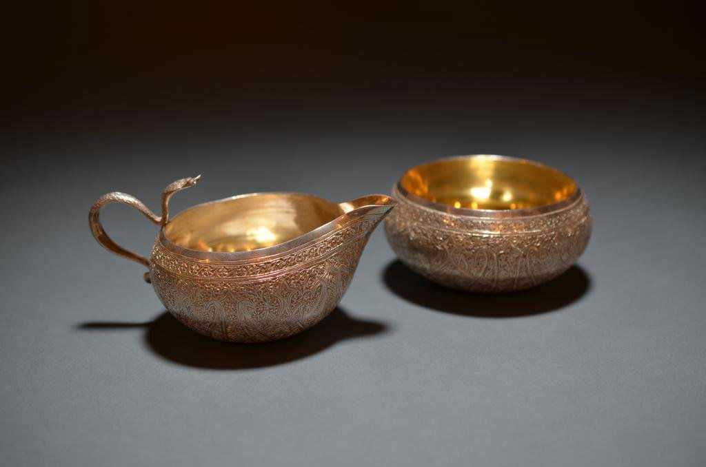 INDIAN COLONIAL SILVER CREAM & SUGAR: an Anglo Indian cream and sugar, Kasmir circa 1900. Each piece engraved in the "Shawl" pattern and gilded in the interior. The cream jug fitted with a snake handle in the form of a cobra. 276 g. Sugar