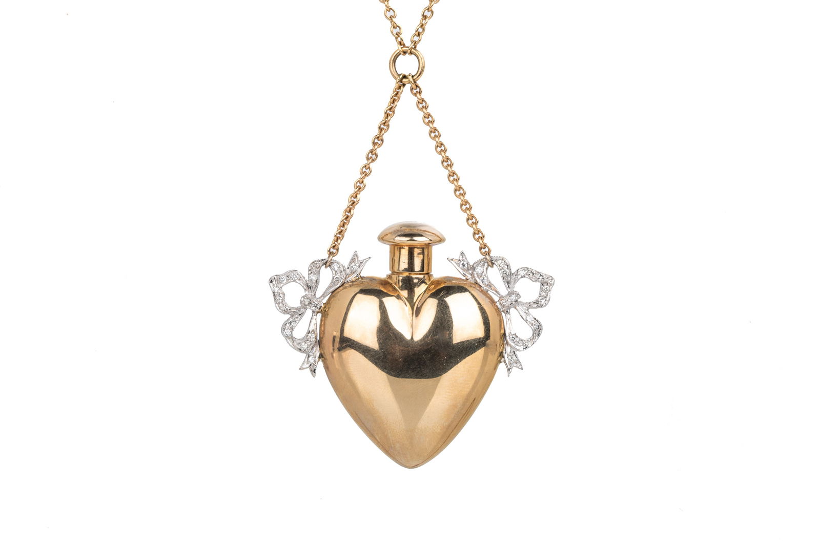 14K GOLD & DIAMOND PERFUME HOLDER NECKLACE, 43.9g: A vintage 14k yellow gold heart-shaped perfume holder flask pendant, accented by two white gold and diamond set bows, with screw off lid applicator, on a long 14k yellow gold chain, both marked 14k, p