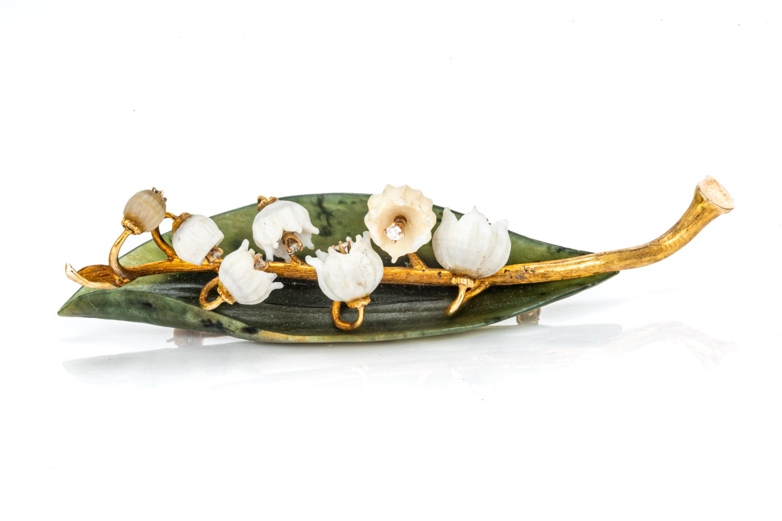 YELLOW GOLD LILY OF THE VALLEY BROOCH, 12.5g: A yellow gold lily of the valley shaped pin brooch, set with diamond-like stones and jadeite, 12.5g. Testing as low carat gold. L. 7.5cm